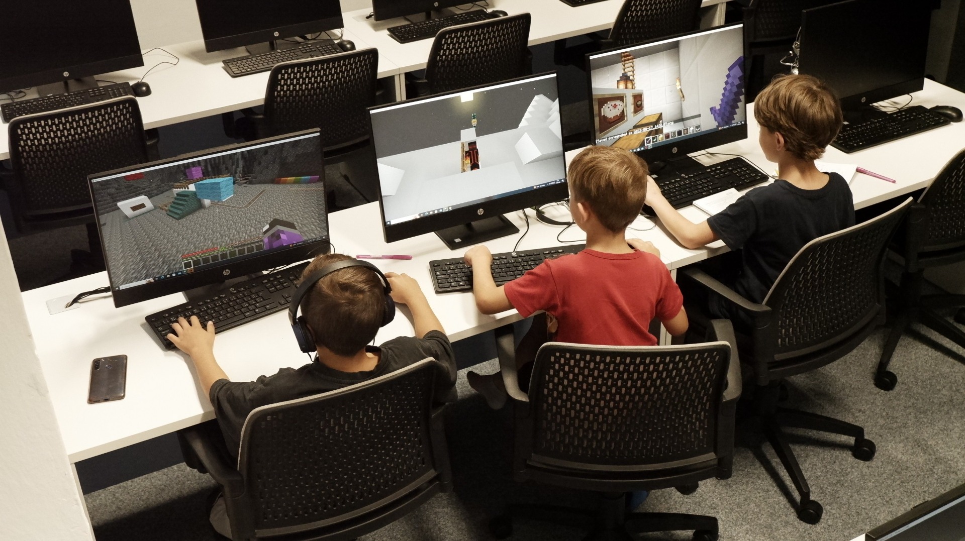 Skupina dětí spolupracuje při tvorbě projektu v IT kroužku Bridge Academy